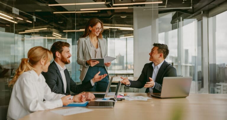 A dynamic business meeting in a modern office brings together diverse professionals for innovation